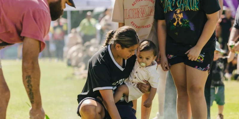Woman holding a child surrounded by other people